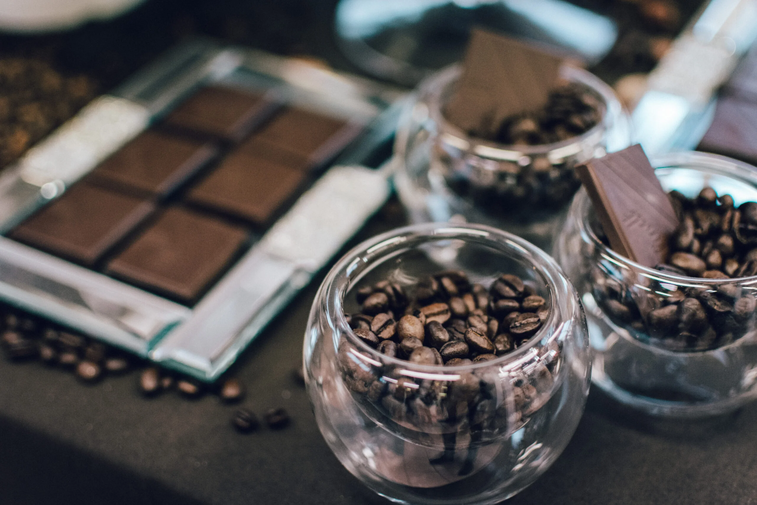 Dark chocolate bar and coffee beans in bowls